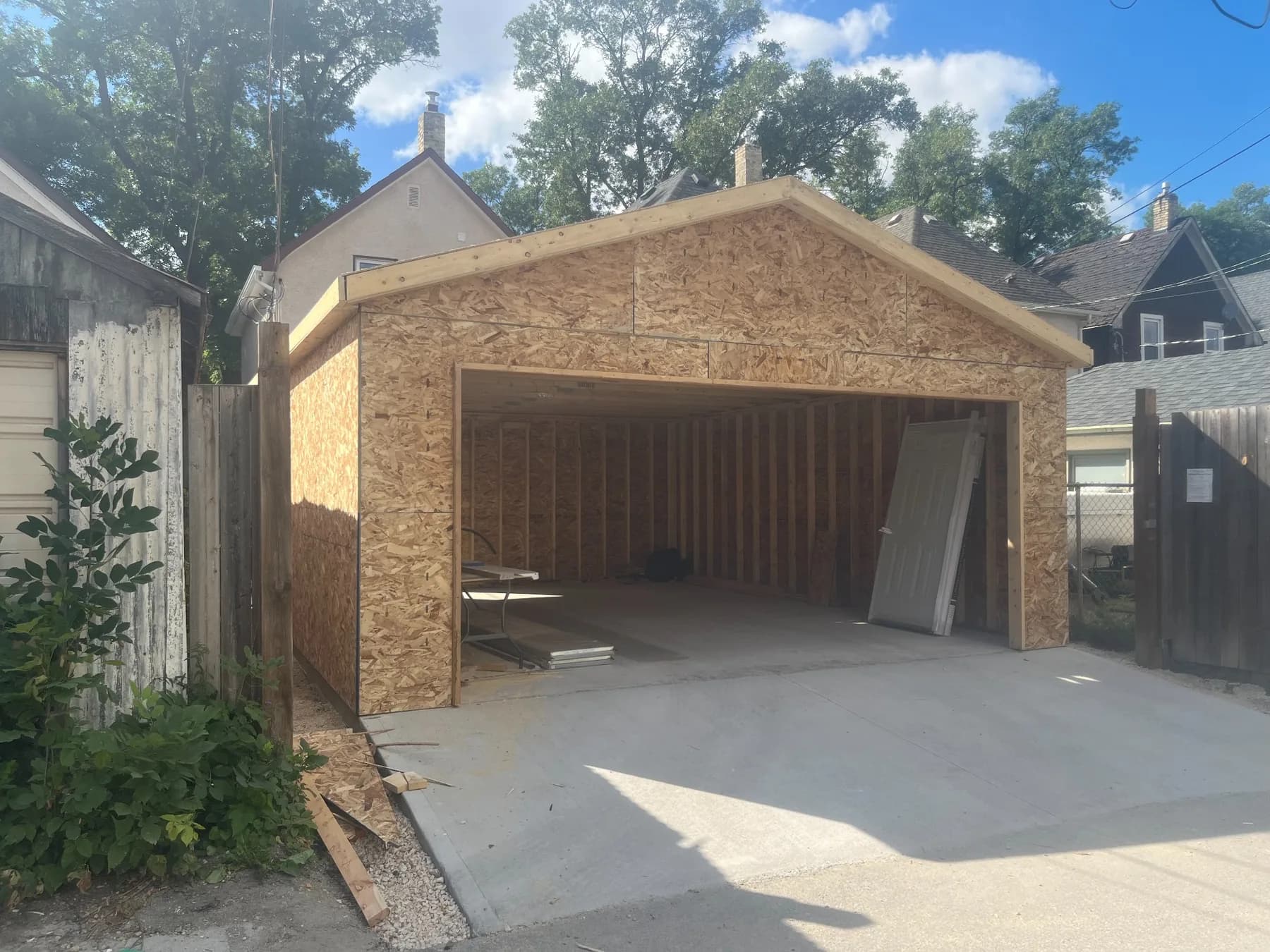Detached garage under construction in Winnipeg with wall and roof sheathing completed